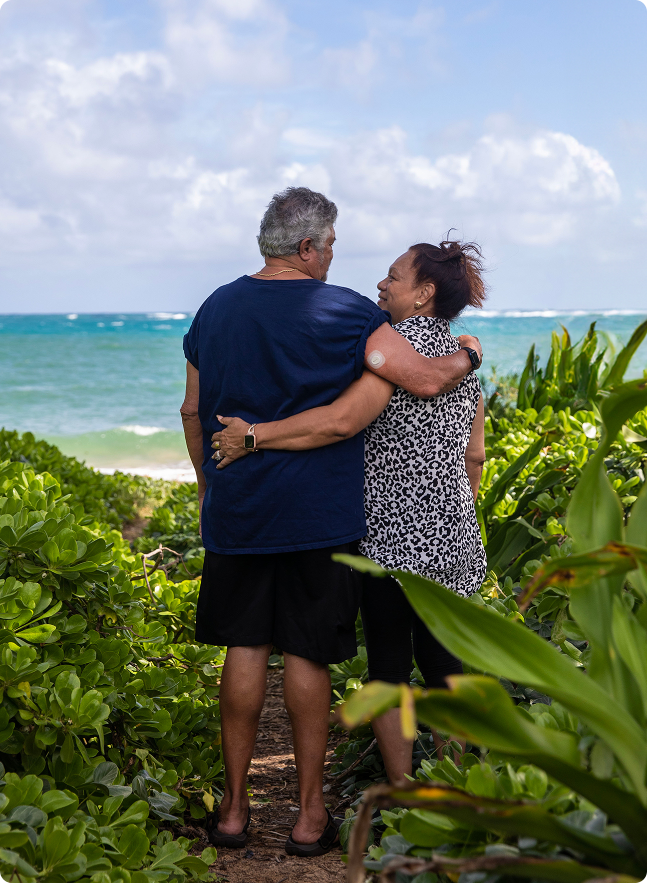 Couple with arms around each other in tropical setting man with G7 sensor back of arm